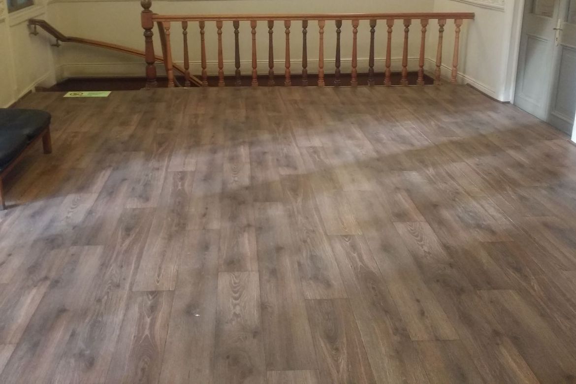 Hall de casona patrimonial con baranda de madera torneada y piso nuevo